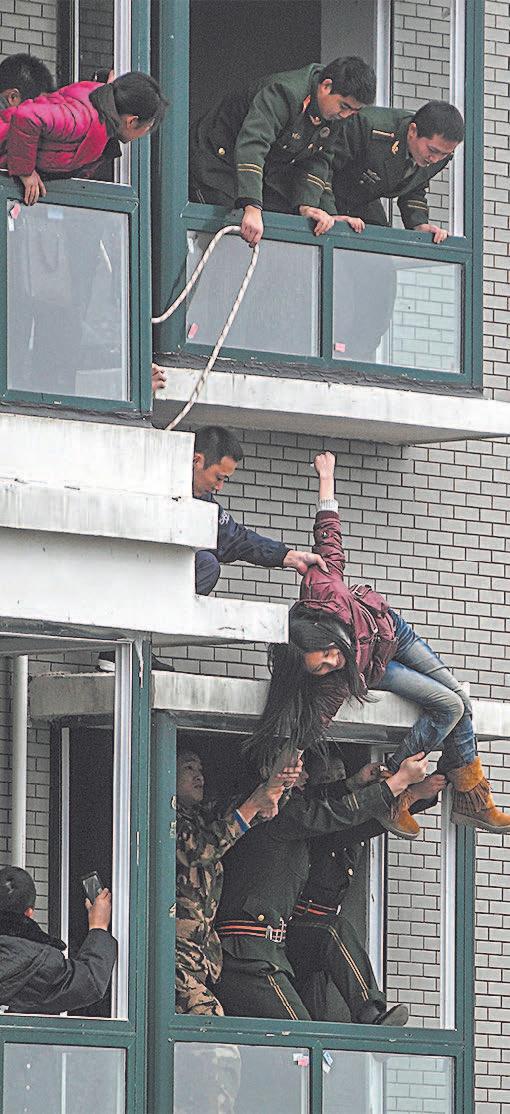 A Chinese woman who attempted to jump off the 33rd floor of an apartment building in Changsha, in China's Hunan Province, on Feb. 28, 2012. (STR/AFP/Getty Images)