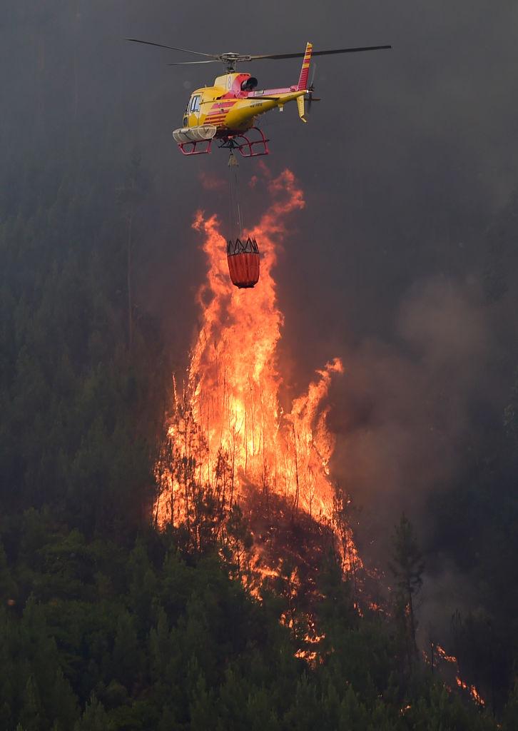 A helicopter overfly a wildfire in Carvalho, next to Pampilhosa da Serra, on June 19, 2017. (MIGUEL RIOPA/AFP/Getty Images)