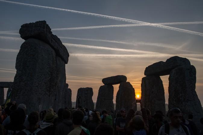 Revelers watch the sunrise as they celebrate the pagan festival of Summer Solstice at Stonehenge in Wiltshire, England, on June 21, 2017. The festival, which dates back thousands of years, celebrates the longest day of the year when the sun is at its maximum elevation. (CHRIS J RATCLIFFE/AFP/Getty Images)
