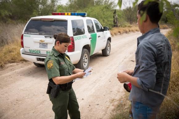 Marlene Castro, supervisory Border Patrol agent, checks the birth certificates of a group of unaccompanied minors who just crossed the Rio Grande from Mexico into the United States in Hidalgo County, Texas, on May 26. (Benjamin Chasteen/The Epoch Times)