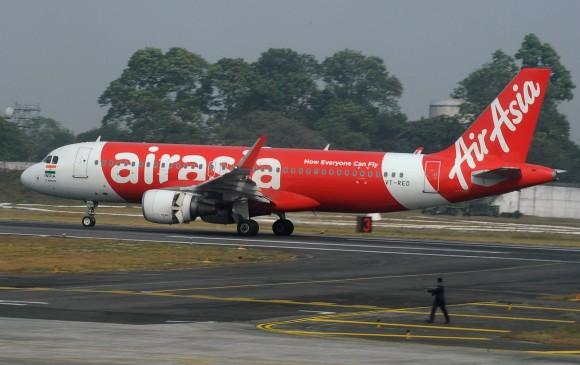 In this file photo, an Indian airport staff member walks next to an AirAsia airplane after it landed on its inaugural flight from New Delhi to Bagdogra Airport on February 19, 2017. (Diptendu Dutta/AFP/Getty Images)