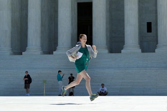 A news assistant runs out after the U.S. Supreme Court granted parts of the Trump administration's emergency request to put his travel ban into effect immediately while the legal battle continues, in Washington on June 26, 2017. (REUTERS/Yuri Gripas)