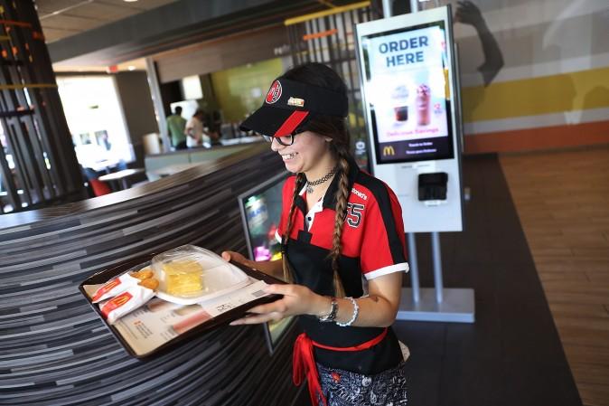 McDonald's crew member Crystalle Martin carries an order to a customers table as the McDonald's restaurant on April 25, 2017 in Miami, Florida. (Joe Raedle/Getty Images)