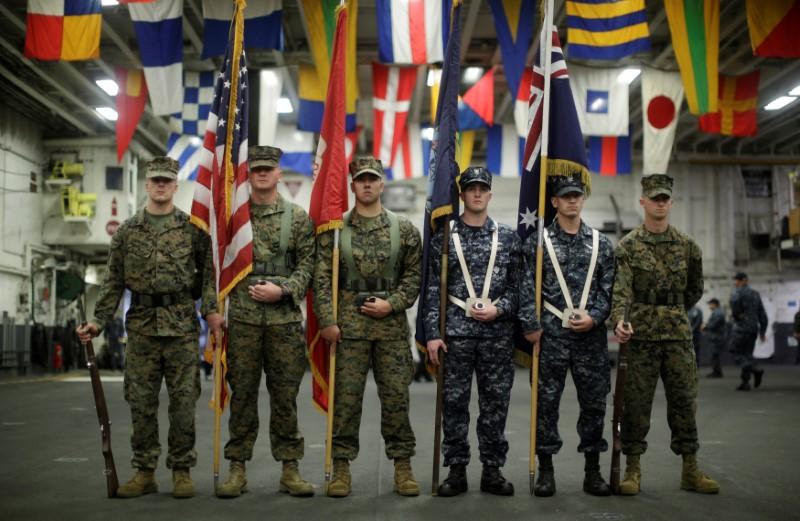 A flag party of U.S. Marines and Navy personnel take part in a ceremony marking the start of Talisman Saber 2017, a biennial joint military exercise between the United States and Australia aboard the USS Bonhomme Richard amphibious assault ship on the the Pacific Ocean off the coast of Sydney, Australia, June 29, 2017. (REUTERS/Jason Reed)