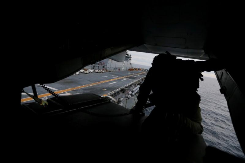 A crewman aboard a U.S. Marines MV-22B Osprey Aircraft looks out over the deck of the USS Bonhomme Richard amphibious assault ship before landing on it off the coast of Sydney, Australia, at the start of Talisman Saber 2017, a biennial joint military exercise between the United States and Australia June 29, 2017. (REUTERS/Jason Reed)