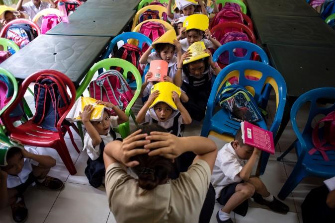 Schoolchildren from the Corazon Aquino Elementary School participate in a nationwide earthquake drill in Manila on June 29.<br/>The nationwide drill is part of the Philippine government's disaster preparedness program and is held quarterly. (NOEL CELIS/AFP/Getty Images)