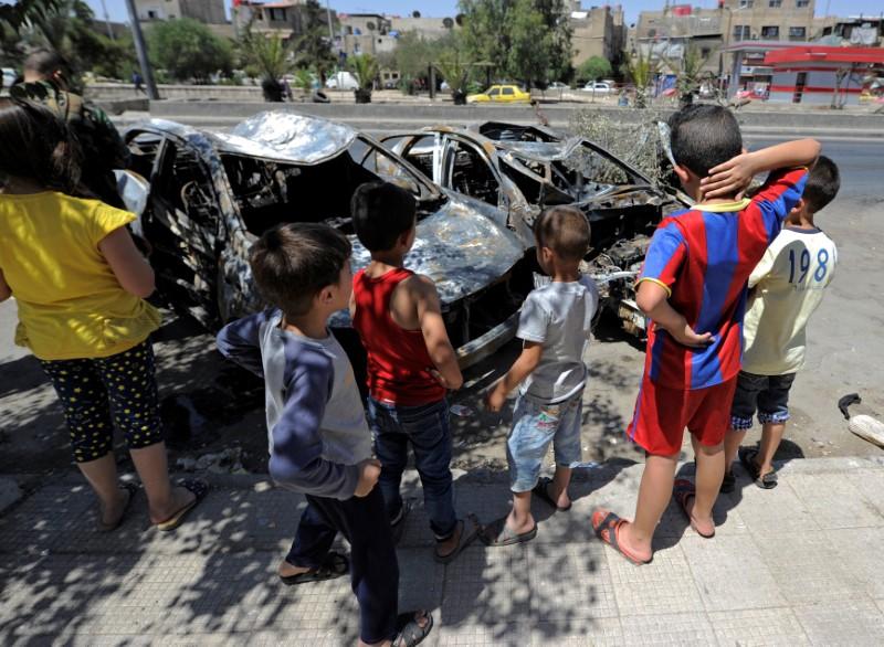 Children look at the wreckage of vehicles at a blast site in the Baytara traffic circle near the Old City of Damascus, Syria July 2, 2017. (Reuters/Omar Sanadiki)