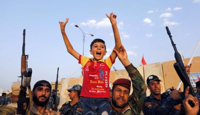 Members of Iraqi Federal Police carry a boy as they celebrate victory of military operations against the ISIS terrorists in West Mosul, Iraq, July 2, 2017. (REUTERS/Erik De Castro)