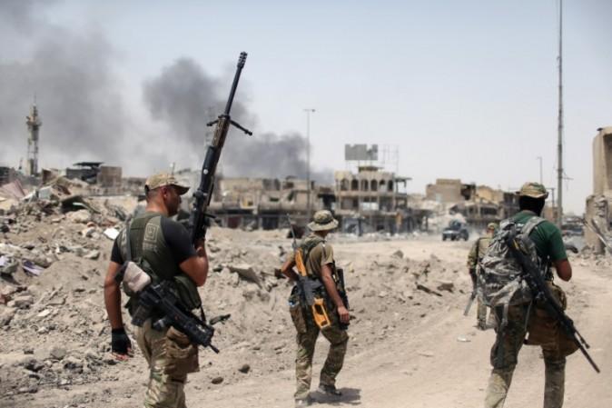 Members of the Emergency Response Division walk with their weapons during the fight with the ISIS terrorists in the Old City of Mosul, Iraq, July 3, 2017. (REUTERS/Ahmed Jadallah)