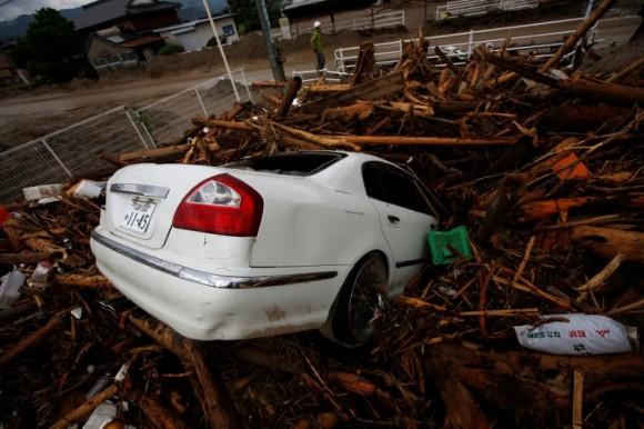 Debris and a car which were swept by heavy rain are seen in Asakura, Fukuoka Prefecture, Japan July 8, 2017. (Reuters/Issei Kato)