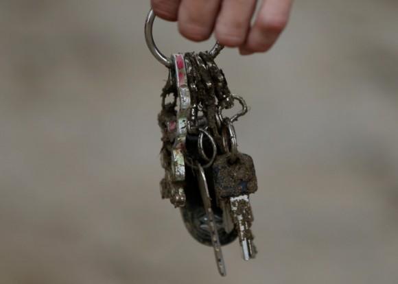 A local resident holds a muddy key holder which he found from his mud covered house at an area hit by heavy rain in Asakura, Fukuoka Prefecture, Japan July 8, 2017. (Reuters/Issei Kato)