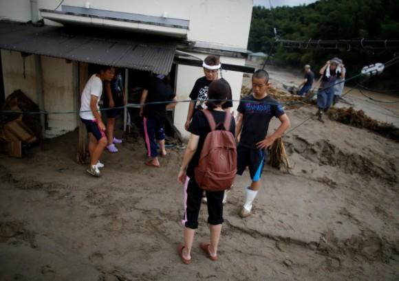 Local resident Mamoru Fujiwara and his family members look for their personal belongings at their mud-covered house at an area hit by heavy rain in Asakura, Fukuoka Prefecture, Japan July 8, 2017. (Reuters/Issei Kato)