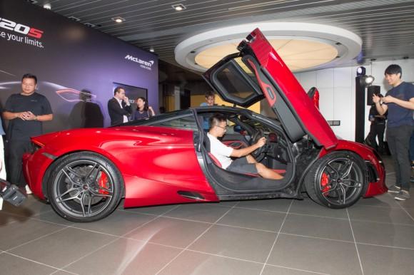 People from the media pour over the McLaren 720S at the Wanchai showroom for its Hong Kong launch on June 29, 2017. (Bill Cox/Epoch Times)