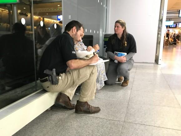 Agents from Homeland Security Investigations speak to the mother of a 14-year-old girl who is about to fly alone to Egypt, at JFK International Airport on June 26, 2017. The agents are concerned the young girl may be subject to female genital mutilation once in Egypt. (Benjamin Chasteen/The Epoch Times)