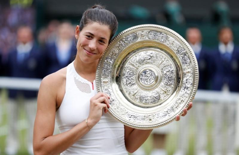 Spain's Garbine Muguruza poses with the trophy as she celebrates winning the final against Venus Williams of the U.S. (REUTERS/Matthew Childs)