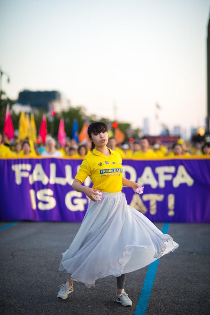 A woman performs a song and dance at a rally in front of Chinese Consulate in New York calling for an end to the Falun Gong persecution inside China in New York on July 16, 2017. (Benjamin Chasteen/The Epoch Times)