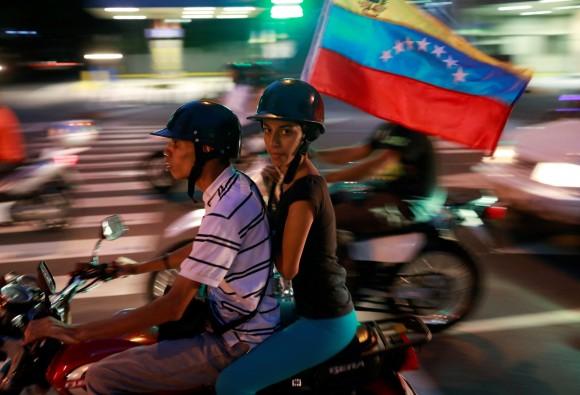 Opposition supporters ride on a motorcycle after an unofficial plebiscite against President Nicolas Maduro's government and his plan to rewrite the constitution, in Caracas, Venezuela July 16, 2017. (Reuters/Marco Bello)