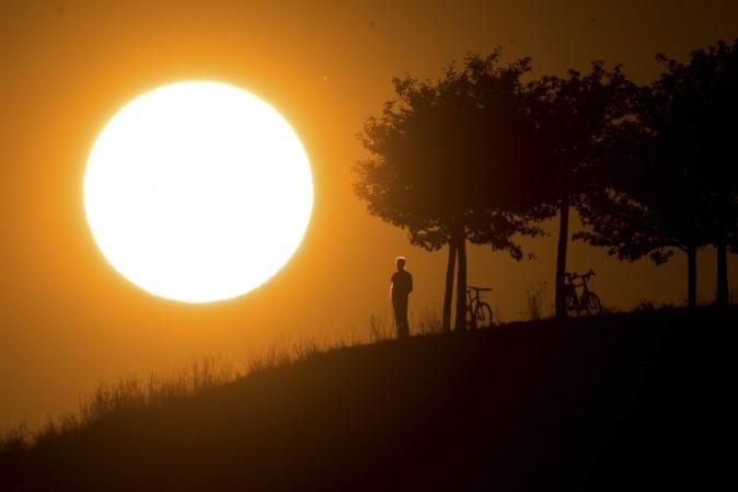 A man looks at the setting sun near Hanover, northern Germany, on July 17, 2017. (JULIAN STRATENSCHULTE/AFP/Getty Images)