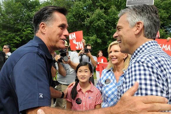 FILE PHOTO: Republican presidential candidates Former Ambassador to China Jon Huntsman (R) and former Massachusetts governor Mitt Romney (L) greet to each other prior to marching in a Fourth of July parade as Huntsman's wife Mary Kaye (2nd R) and daughter Gracie Mei look on July 4, 2011 in Amherst, New Hampshire. (Photo by Darren McCollester/Getty Images)