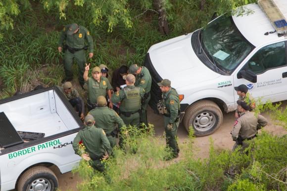 A Border Patrol agent signals to a Customs and Border Protection helicopter crew that two aliens from a group of seven they tried to capture have escaped, near Salineño, Texas, on May 30, 2017. (Benjamin Chasteen/The Epoch Times)