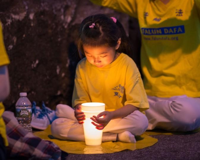 A little girl attends a candlelight vigil in front of the Chinese Consulate in New York on July 16, 2017. (Benjamin Chasteen/The Epoch Times)