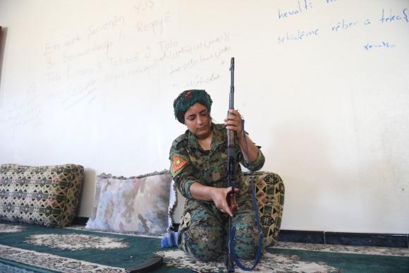 Heiza, a Yazidi fighter from the Shengal Women's Units (YPS), a group of women fighters from Iraq's northeastern Sinjar region supporting the Women's Protection Units (YPG), prepares her rifle in an abandoned home used by the YPS as their base in Al-Meshleb, on the eastern outskirts of Raqa on July 18, 2017. (BULENT KILIC/AFP/Getty Images)