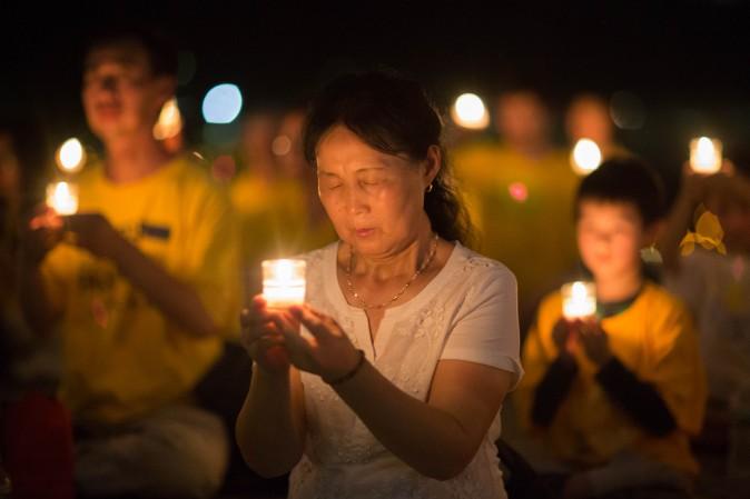 A woman joins Falun Gong practitioners at a candlelight vigil at the Lincoln Memorial in Washington on July 20, 2017, to honor the lives lost since the Chinese regime launched the persecution eighteen years ago. (Benjamin Chasteen/The Epoch Times)