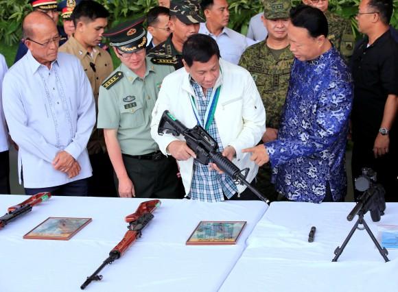 File photo: Philippine President Rodrigo Duterte inspects an automatic rifle while Defense Secretary Delfin Lorenzana (L), Wang Xianyun (2-L) military and defence attache of the People's Republic of China and H.E. Zhao Jianhua (R), ambassador of China to the Philippines look on, during the turnover ceremony of China's urgent military assistance, given "gratis" to the Philippines at Clark Air Base, Philippines June 28, 2017. (Reuters/Romeo Ranoco)