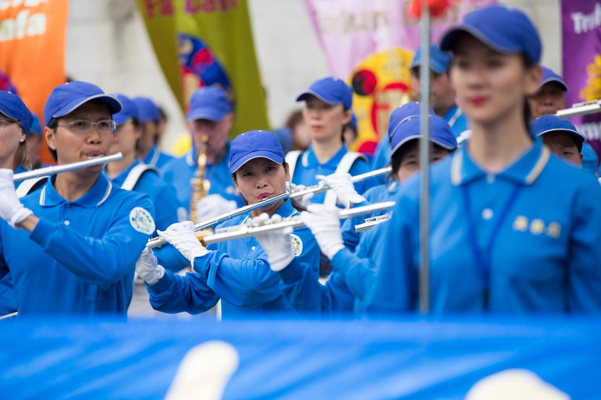 A European marching band and peaceful protestors in Trafalgar Square call for an end to the 18-year-long persecution of Falun Gong. The music from the marching band is uplifting, yet the personal stories of some of the members are heartbreaking. (Si Gross/The Epoch Times)