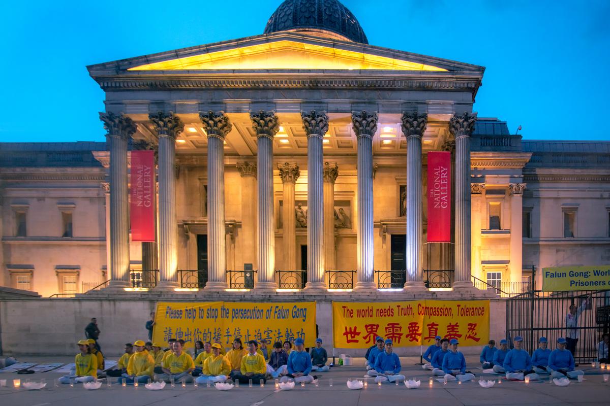 Practitioners of Falun Gong hold a candle-lit vigil outside the National Gallery in Trafalgar Square on 23 July 2017, appealing for an end to an 18-year-long persecution. (Yanning Qi/The Epoch Times)