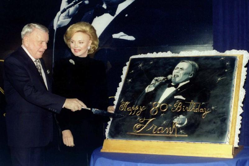 Music legend Frank Sinatra, joined by his wife Barbara, cuts an oversize 80th birthday cake during a ceremony in his honor, at a New York hotel in New York City, U.S. on November 30, 1995. (REUTERS/Mark Cardwell)
