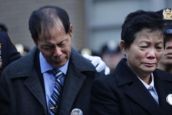 Wei Tang Liu (L), the father of Detective Wenjian Liu, and Xiu Yan Li, his mother,  grieve during a plaque dedication ceremony for their son and NYPD Detective Rafael Ramos at the 84th Precinct in Brooklyn on Dec. 20, 2015 in New York City. Detectives Ramos and Liu were fatally shot while sitting in their patrol car in Bedford-Stuyvesant one-year prior. The gunman, Ismaaiyl Brinsley, then killed himself. (Spencer Platt/Getty Images)