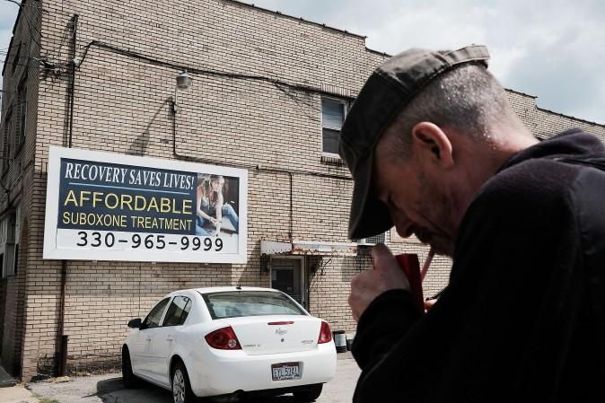 A man near a billboard for a drug recovery center in Youngstown, Ohio, on July 14, 2017. (Spencer Platt/Getty Images)