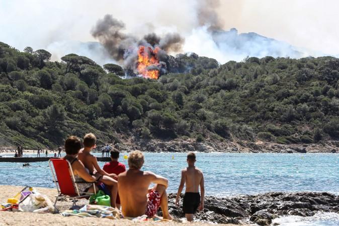 People on the beach look at a forest fire in La Croix-Valmer, France, on July 25, 2017. Firefighters battled blazes that have consumed swathes of land in southeastern France for a second day, with one inferno out of control near the chic resort of Saint-Tropez. (VALERY HACHE/AFP/Getty Images)