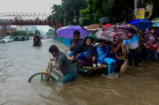 Commuters use a rickshaw to cross a flooded street amid heavy rainfall in Dhaka, Bangladesh, on July 26, 2017. Bangladesh is experiencing downpours following a depression forming in the Bay of Bengal. (MUNIR UZ ZAMAN/AFP/Getty Images)