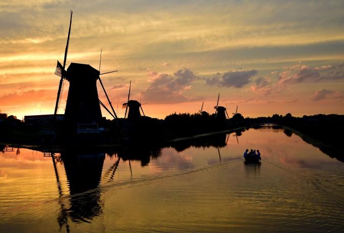 People sail on a small boat at sunset in the village of Kinderdijk in the Netherlands on July 31, 2017. (TOBIAS SCHWARZ/AFP/Getty Images)