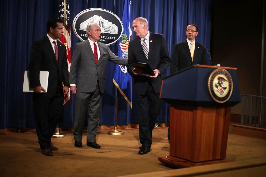 U.S. Attorney General Jeff Sessions (2nd L) and Director of National Intelligence Dan Coats (3rd L) share a moment as Deputy Attorney General Rod Rosenstein (R) and National Counterintelligence and Security Center Director William Evanina (L) look on during an event at the Justice Department in Washington, DC, on Aug. 4, 2017. Sessions held the event to discuss "leaks of classified material threatening national security." (Alex Wong/Getty Images)
