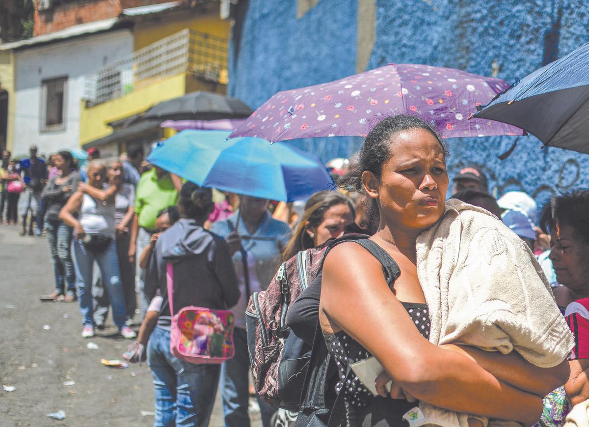 People line up to buy basic food and household items outside a supermarket in Caracas, Venezuela, in 2016. (RONALDO SCHEMIDT/AFP/GETTY IMAGES)