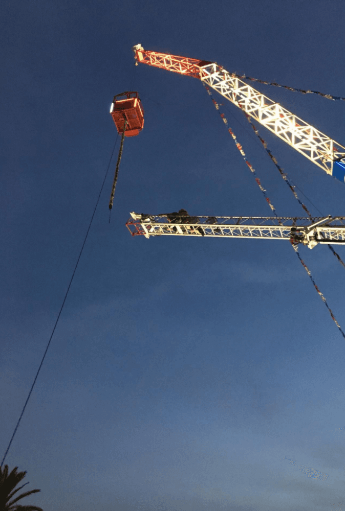 Firefighters use ropes to rappel down a ride operator and customer from a cage suspended by a crane at the Ventura City County Fair on Aug 2, 2017. (Ventura City Fire Deptartment)