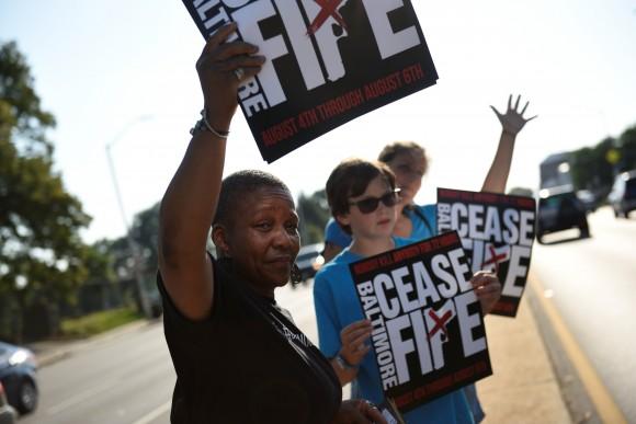 People hold signs at the "Stop the Violence" rally at the intersection of Edmondson Avenue and Wildwood Parkway during the 72 hour community-led Baltimore Ceasefire against gun violence in Baltimore, Maryland, U.S. August 4, 2017. (Reuters/Sait Serkan Gurbuz)