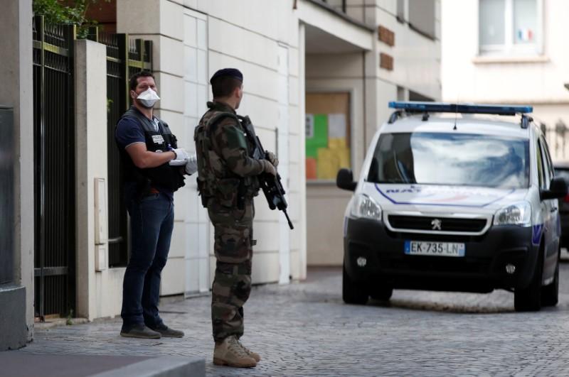 A police investigator and an armed soldier work near the scene where French soliders were hit and injured by a vehicle in the western Paris suburb of Levallois-Perret, France, August 9, 2017. REUTERS/Benoit Tessier