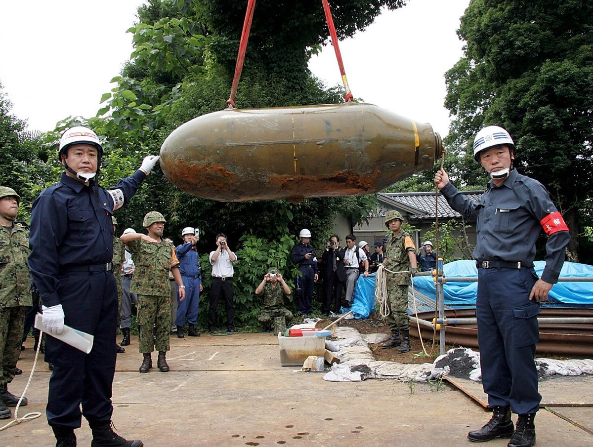 Japan's Ground Self Defence Forces remove an unexploded 1-ton bomb in Nishitokyo, western Tokyo, Japan, on July 10, 2005. The bomb was supposedly dropped by the U.S. military during the WWII. (Nishitokyo City via Getty Images)