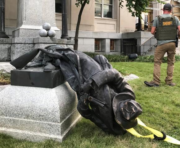 A Sheriff's deputy near the toppled statue of a Confederate soldier in front of the old Durham County Courthouse in Durham, N.C., U.S. Aug. 14, 2017. (Kate Medley/Reuters)