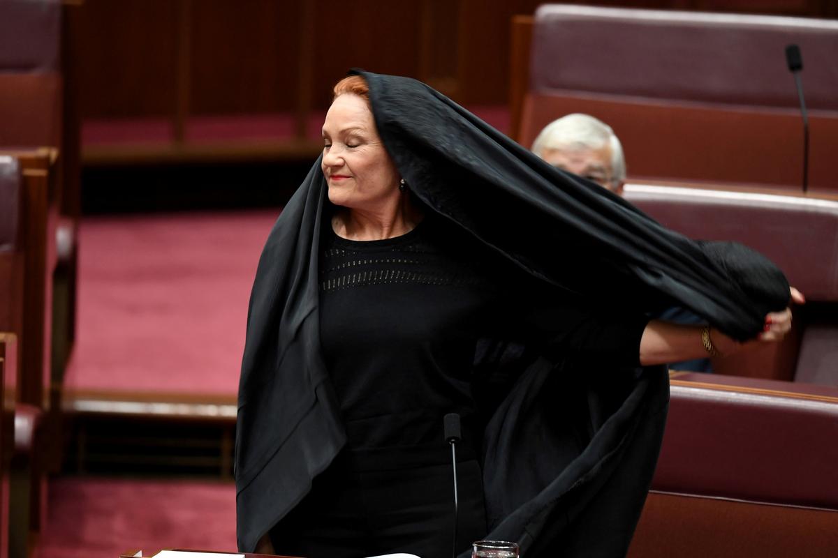 Australian One Nation party leader, Senator Pauline Hanson pulls off a burqa in the Senate chamber at Parliament House in Canberra, Australia, August 17, 2017. AAP/Mick Tsikas/via REUTERS