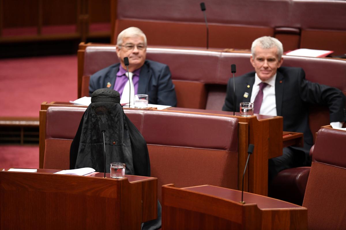 Australian One Nation party leader, Senator Pauline Hanson (L) wears a burqa in the Senate chamber at Parliament House in Canberra, Australia, August 17, 2017. (AAP/Mick Tsikas/via REUTERS)