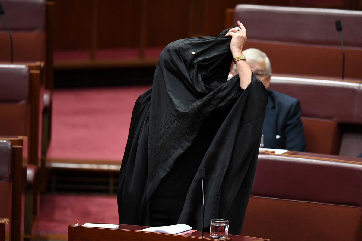Australian One Nation party leader, Senator Pauline Hanson pulls off a burqa in the Senate chamber at Parliament House in Canberra, Australia, August 17, 2017. (AAP/Mick Tsikas/via REUTERS)