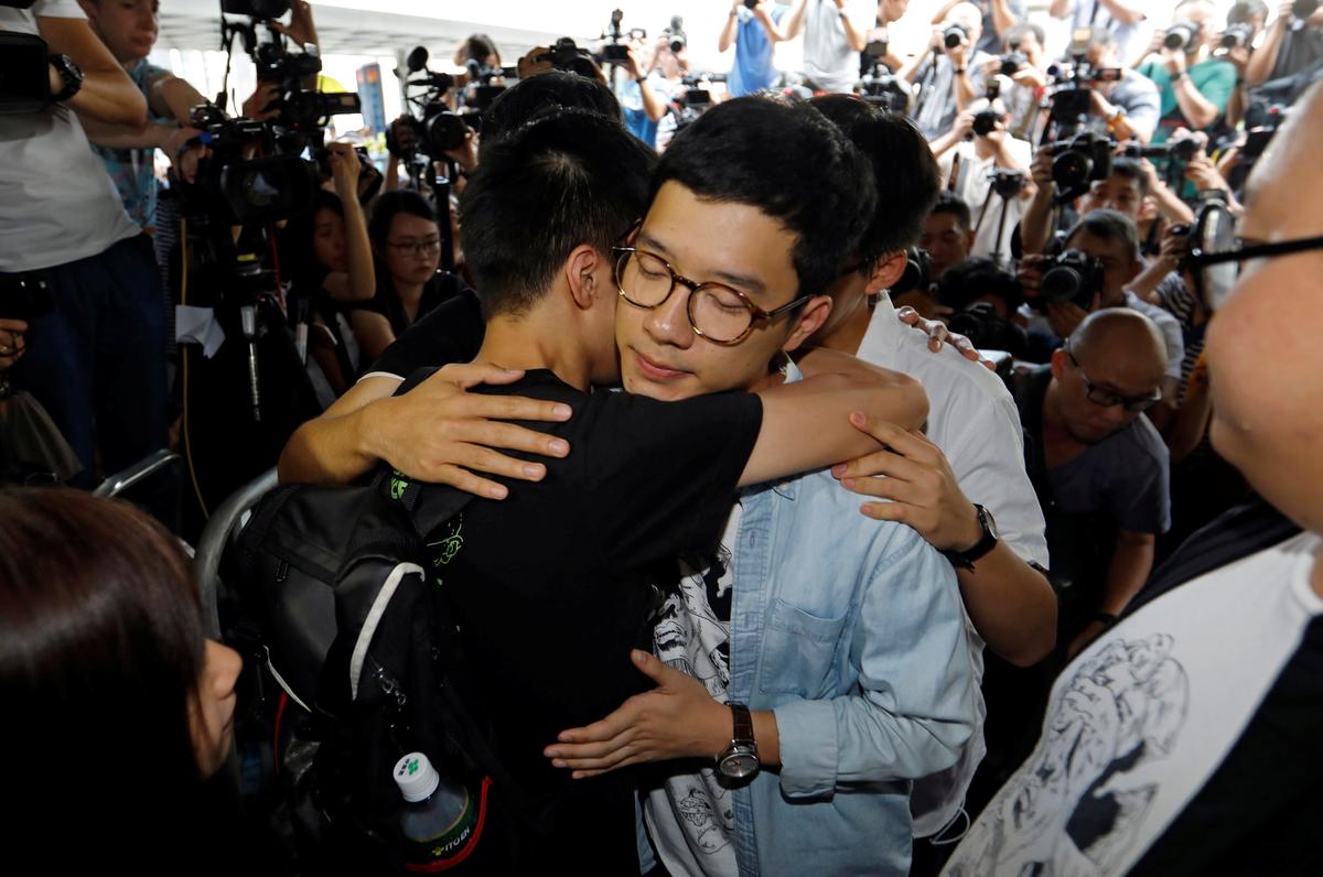 Student leaders Nathan Law and Joshua Wong hug Lester Shum as they arrive at the High Court to face verdict on charges relating to the 2014 pro-democracy Umbrella Movement, also known as Occupy Central protests, in Hong Kong, China on August 17, 2017. (REUTERS/Tyrone Siu)