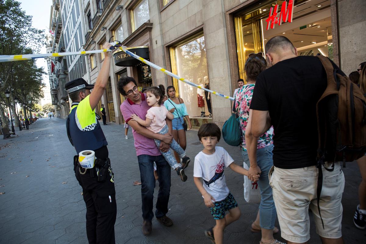 A police officer helps evacuate people after a van crashed into pedestrians near the Las Ramblas avenue in central Barcelona, Spain August 17, 2017. (Ana Jimenez/La Vanguardia/via REUTERS)