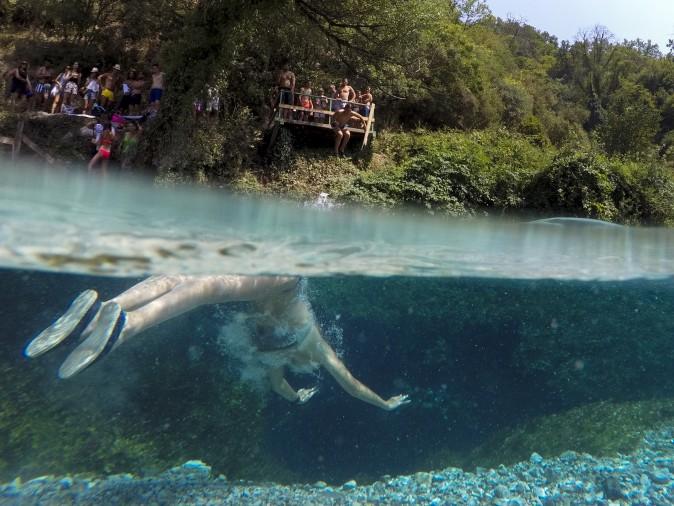 A man swims in the Blue Eye water spring near the city of Sarande, Albania, on Aug. 16, 2017. The clear water of the Blue Eye spring flows from a 50 meters deep pool with a temperature of 10 degrees Celsius (50 °F). (GENT SHKULLAKU/AFP/Getty Images)