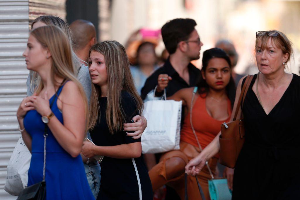 People react as they leave a cordoned off area after a van ploughed into the crowd, killing two persons and injuring several others on the Rambla in Barcelona on August 17, 2017. (JOSEP LAGO/AFP/Getty Images)